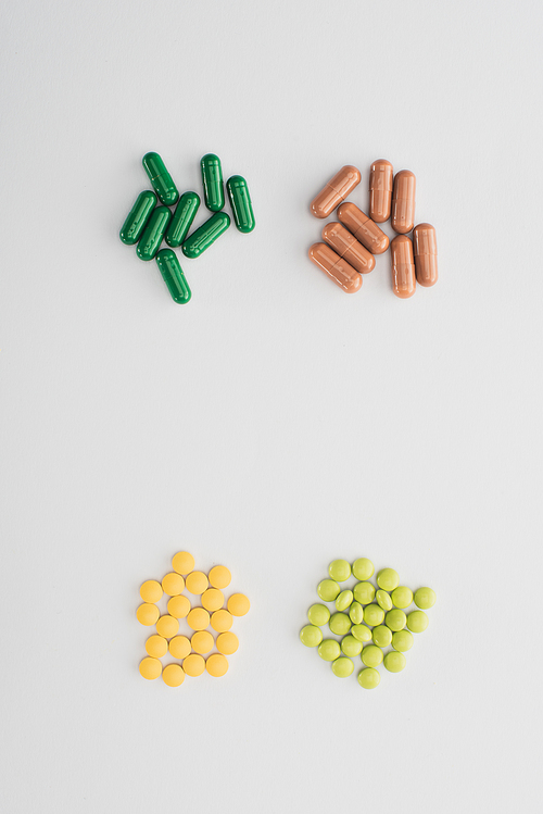 Top view of pills and capsules on white background