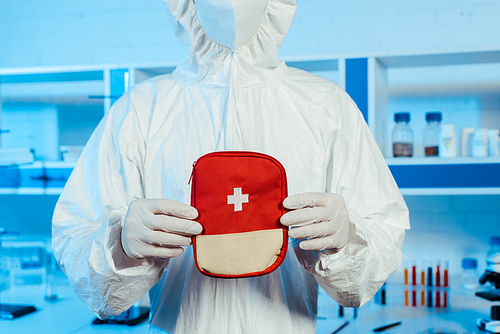 cropped view of scientist in hazmat suit holding first aid kit