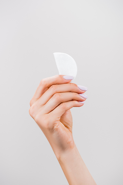 cropped view of woman holding cotton pad isolated on grey