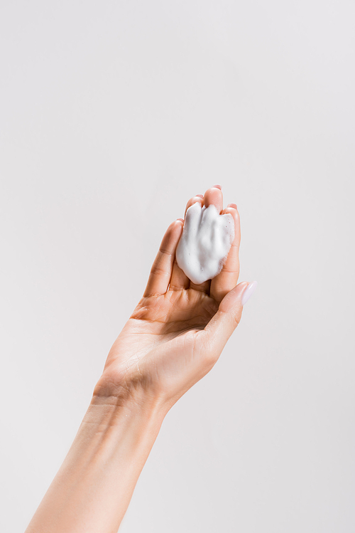 cropped view of woman with cleansing foam isolated on grey