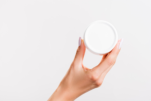 cropped view of woman holding container of hand cream isolated on grey