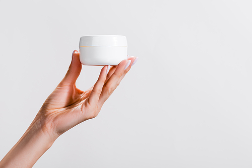 cropped view of woman holding container of hand cream isolated on grey