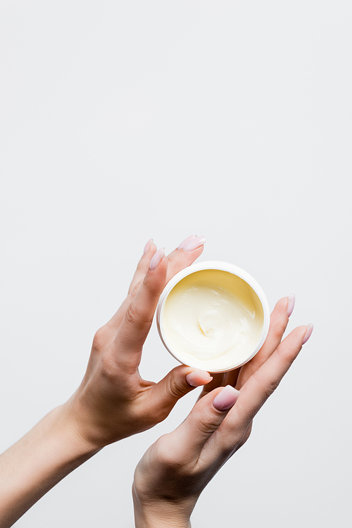 top view of woman holding jar with cosmetic cream isolated on white