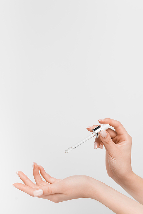 partial view of woman holding pipette with serum isolated on white