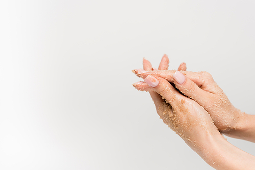 cropped view of woman applying scrub on hands isolated on white