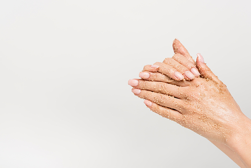 partial view of woman applying scrub on hands isolated on white