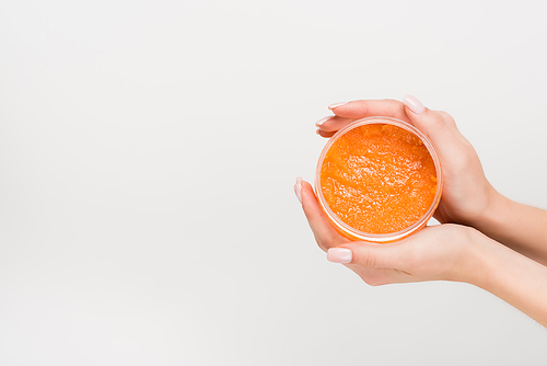 partial view of woman holding container with scrub in hands isolated on white