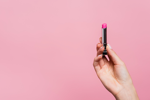 cropped view of woman holding lipstick isolated on pink