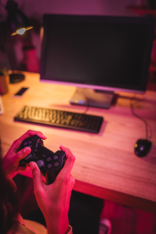 KYIV, UKRAINE - AUGUST 21, 2020: Cropped view of gamer holding joystick near computer on blurred background