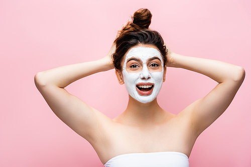 happy beautiful woman with clay mask on face isolated on pink