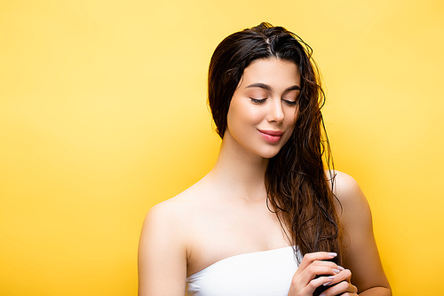smiling beautiful woman with wet hair isolated on yellow