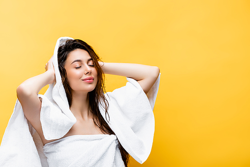 smiling beautiful woman with wet hair and towel isolated on yellow