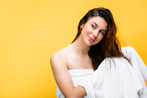 smiling beautiful woman with wet hair and towel isolated on yellow
