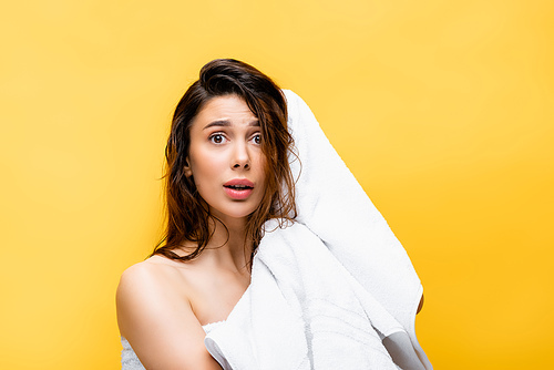 shocked beautiful woman with wet hair and towel isolated on yellow
