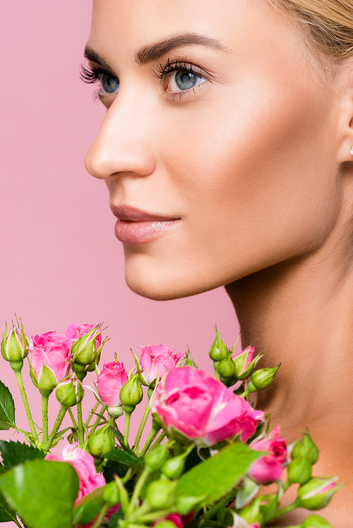 beautiful blonde woman with rose bouquet isolated on pink