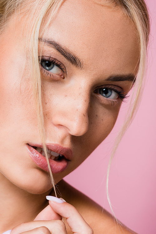beautiful blonde woman with freckles isolated on pink