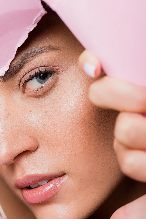 closeup of beautiful woman with freckles in pink paper hole