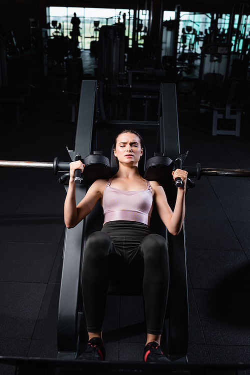 high angle view of athletic sportswoman doing arms extension exercise on training machine