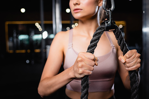 cropped view of sportswoman training triceps on cable pushdown machine on blurred background