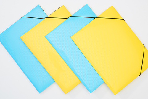flat lay of yellow and blue folders on white background