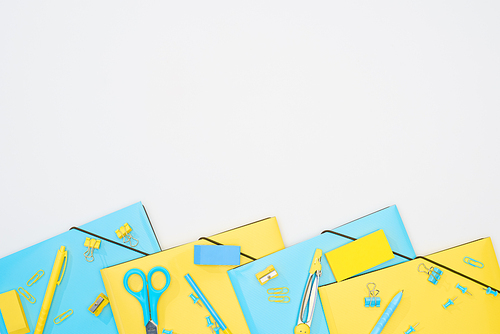 top view of blue and yellow stationery isolated on white