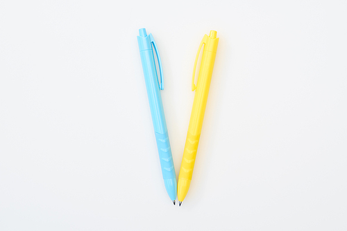 top view of yellow and blue crossed pencils isolated on white