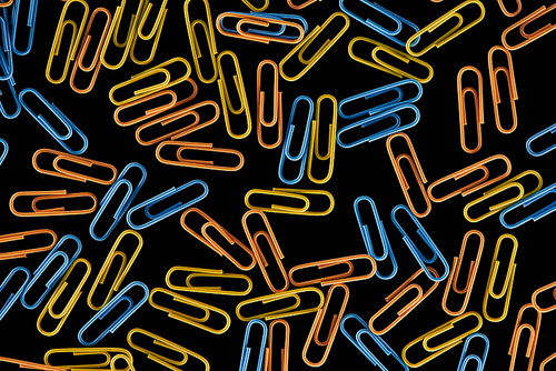 top view of colorful scattered paper clips isolated on black