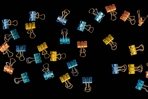 top view of colorful small paper clips isolated on black