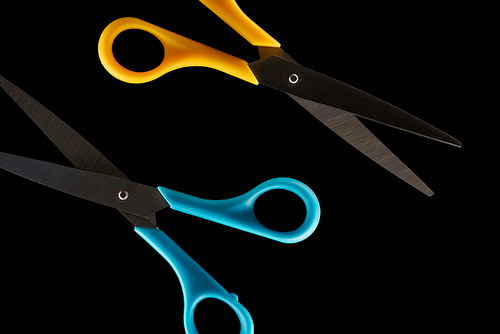 top view of blue and yellow scissors isolated on black