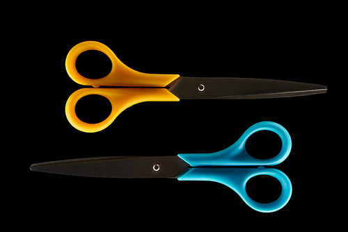 top view two closed scissors isolated on black