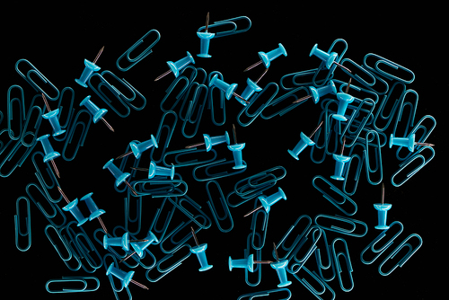 top view of two kinds of paper clips scattered and isolated on black