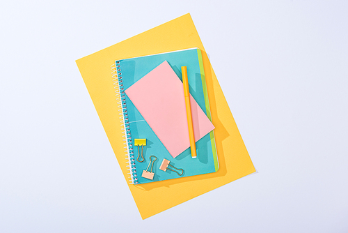 top view of notebooks, binder clips, felt tip pen and paper isolated on white