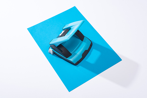 high angle view of holepunch and colorful paper on white background