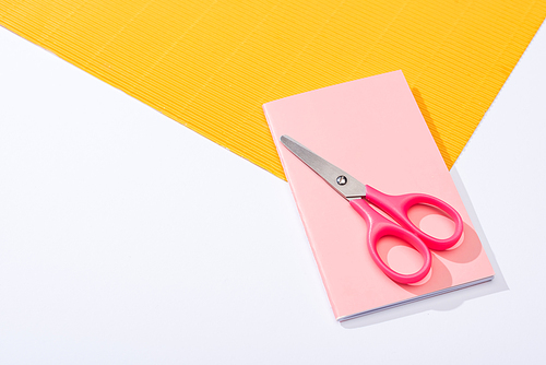 high angle view of scissors, notebook and paper on white background