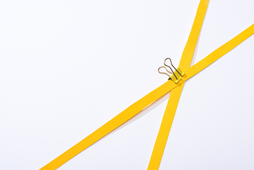 top view of binder clip and paper strips on white background