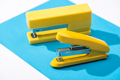 high angle view of staplers and paper isolated on white