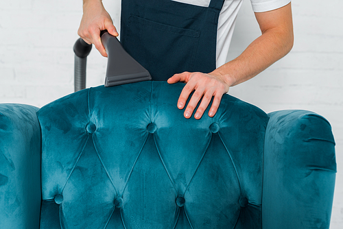 cropped view of cleaner dry cleaning blue modern armchair with vacuum cleaner