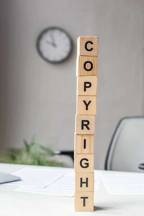 Tower of wooden cubes with copyright lettering on workplace on blurred background