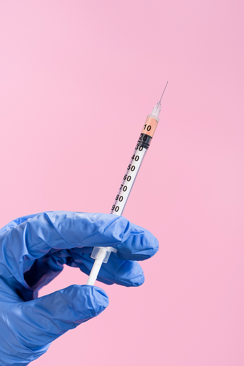 cropped view of hand in latex glove with syringe isolated on pink