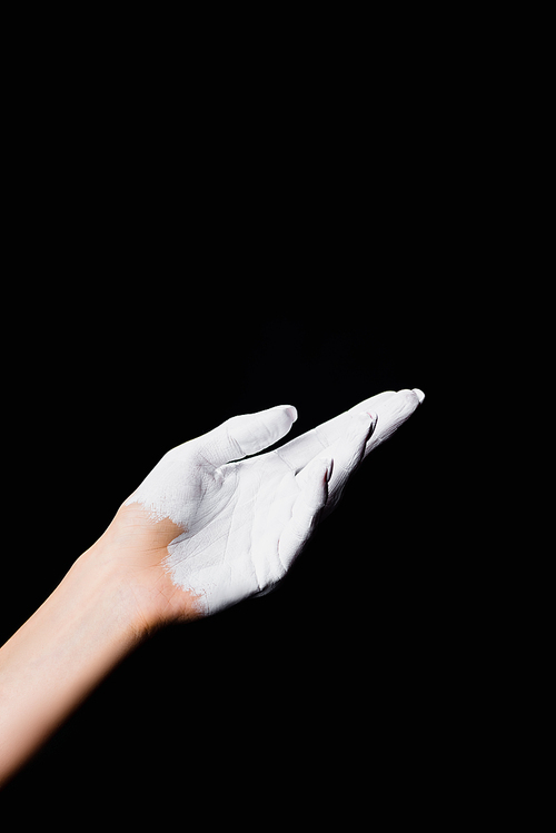 partial view of white painted hand isolated on black