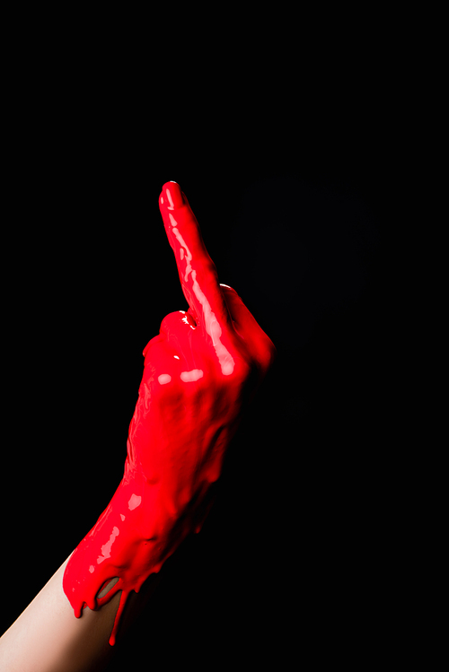 cropped view of hand painted in red paint showing middle finger isolated on black