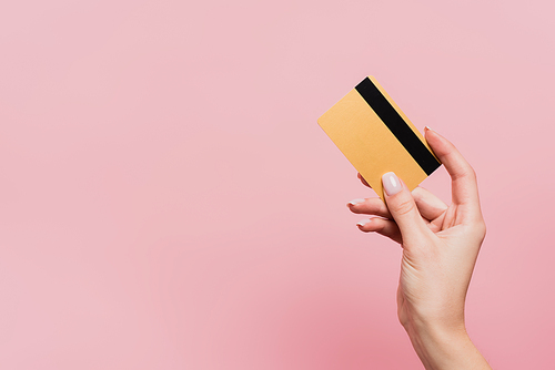 cropped view of woman holding credit card isolated on pink