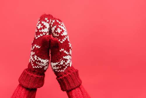 cropped view of female praying hands in warm mittens isolated on red
