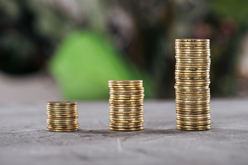 selective focus of golden coins arranged in rows on table