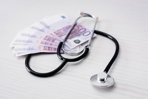 Selective focus of stethoscope with euro banknotes on table