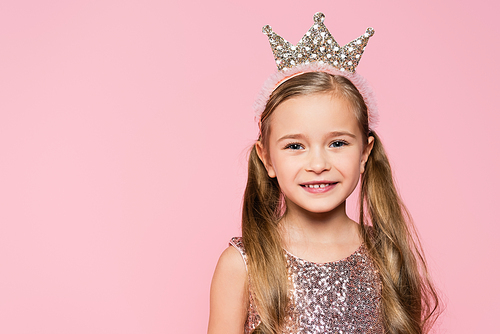 happy little girl in crown smiling isolated on pink