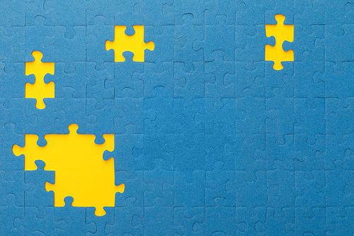 top view of blue jigsaw puzzle with yellow gaps