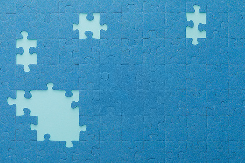 top view of unfinished blue jigsaw puzzle on lighter background