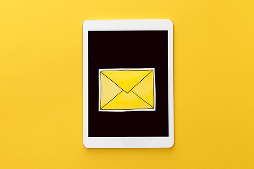 top view of letter on digital tablet with blank screen on yellow background