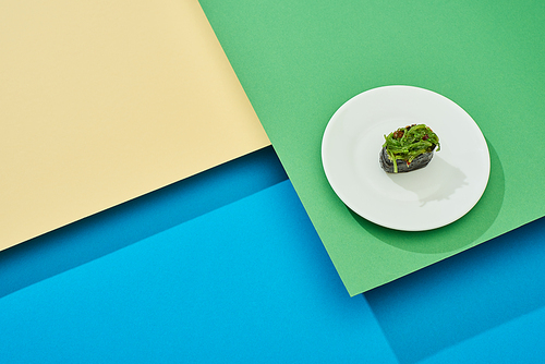 fresh nigiri with seaweed on plate on multicolored surface